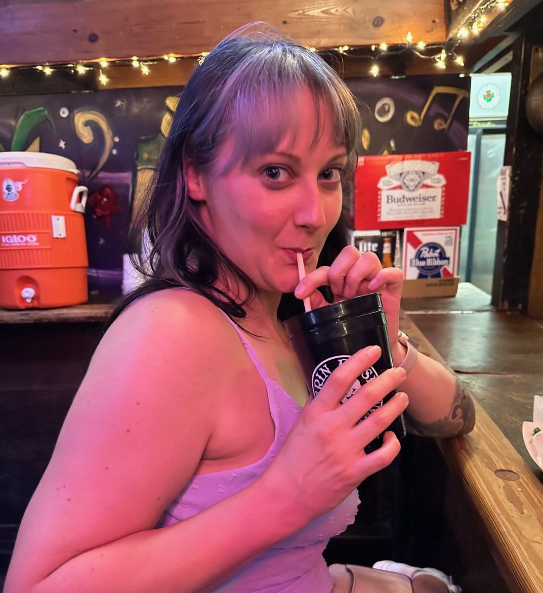 woman sipping from Erin Rose cup through straw