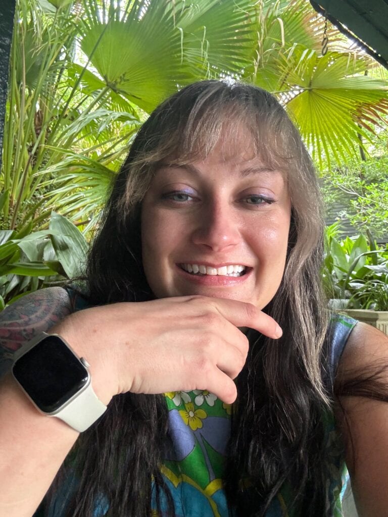 picture of woman smiling in front of fan palms