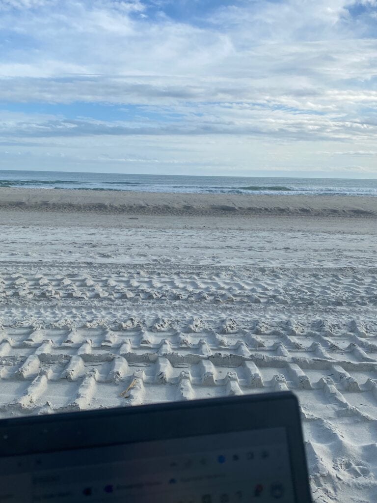 view of laptop screen in front of beach