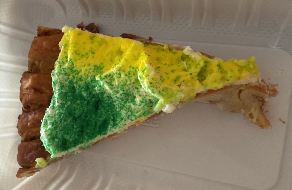 slice of green and yellow cinnamon flavored King Cake