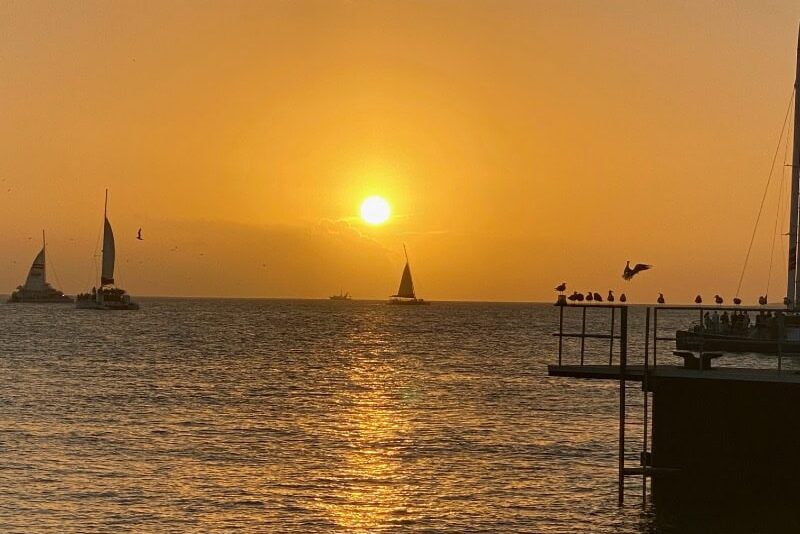 Key West ocean sunset in Mallory Square with 3 sailboats