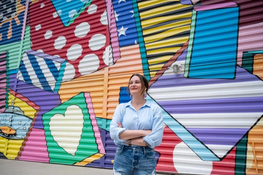 woman standing in front of colorful mural at World Trade Center