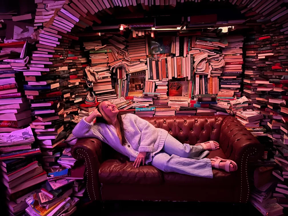 Woman on couch surrounded by books