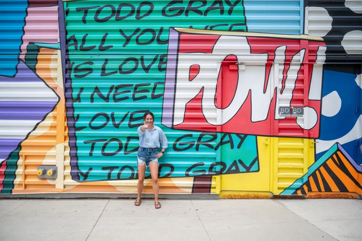 Women posing punching in front of "Pow" sign