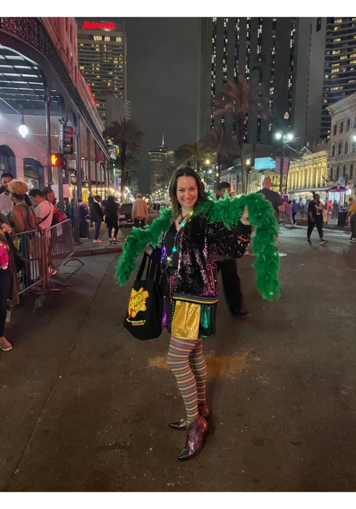 Woman posing with green feather boa at Mardi Gras