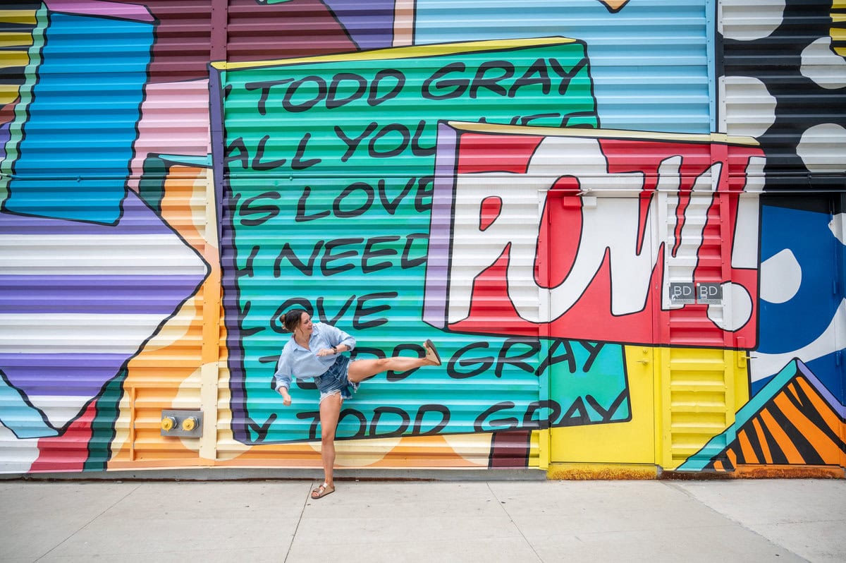 Woman pretending to kick a sign that says 