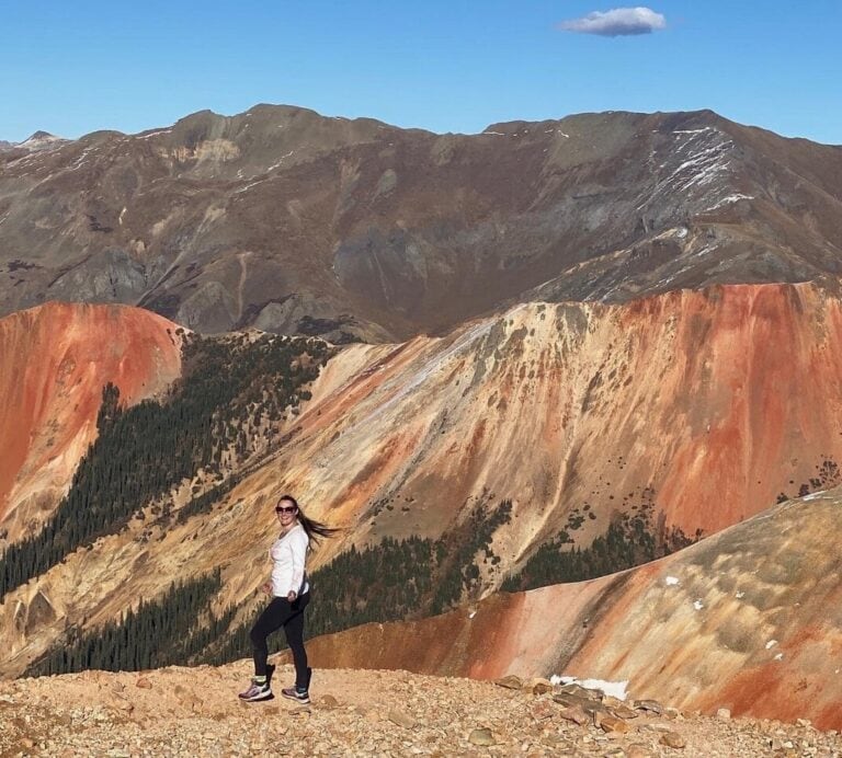 Woman in front of red and brown mountains