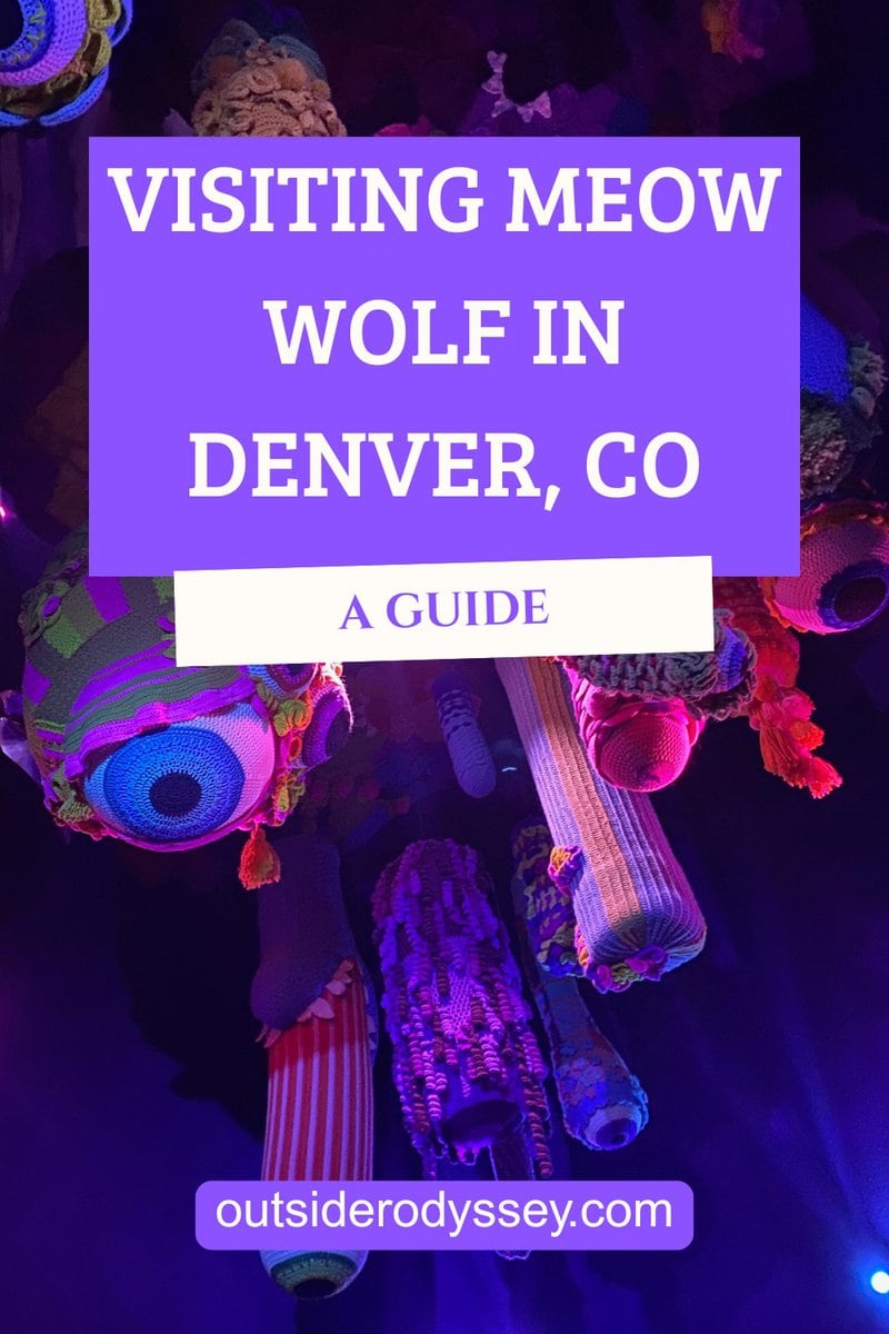 Colorful, yarn-covered sculptures hang from the ceiling under purple and pink lights. Overlaid text reads: Visiting Meow Wolf Denver - A Guide with outsiderodyssey.com at the bottom.