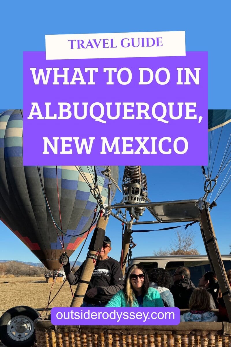 A group of people sit in a hot air balloon basket ready for takeoff, with another colorful balloon in the background and a clear blue sky. Text overlay reads: Things to Do Alone in Albuquerque—Travel Guide: What to do in Albuquerque, New Mexico.