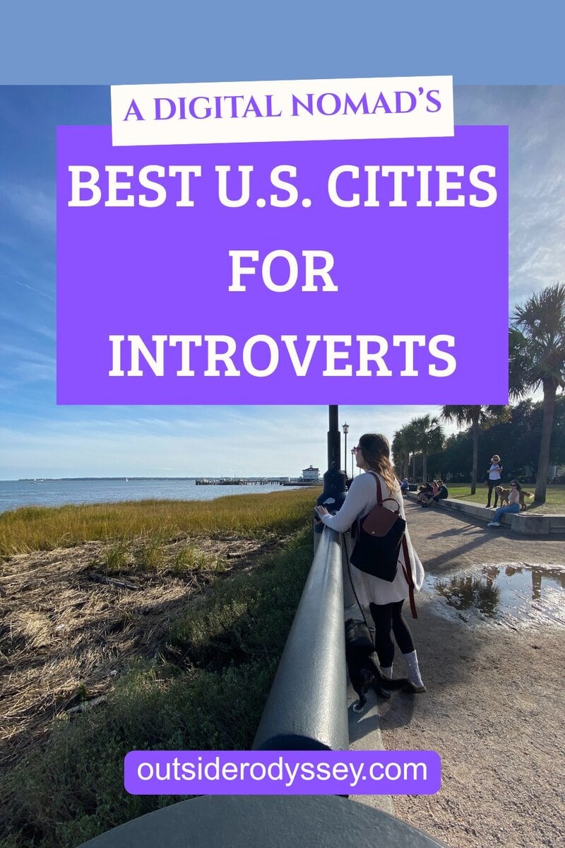 A person stands by a waterfront railing in a park, gazing at the water under a clear blue sky. Overlaid text reads: “Best Cities for Introverts: A Digital Nomad’s Guide, outsideredyssey.com.”.