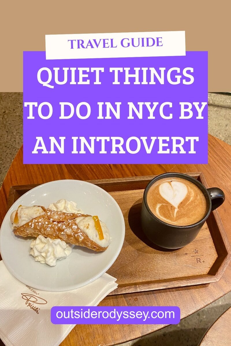 A wooden tray holds a cappuccino with heart-shaped latte art and a cannoli with whipped cream. Text above reads Quiet things to do in NYC by an introvert - quiet things to do in nyc at outsiderodyssey.com.