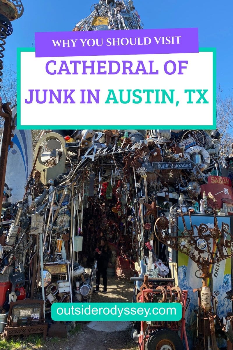 A colorful sign reading Cathedral of Junk invites visitors to explore Austin’s unique outdoor structure made of scrap metal and found objects. Discover more at outsiderodyssey.com.