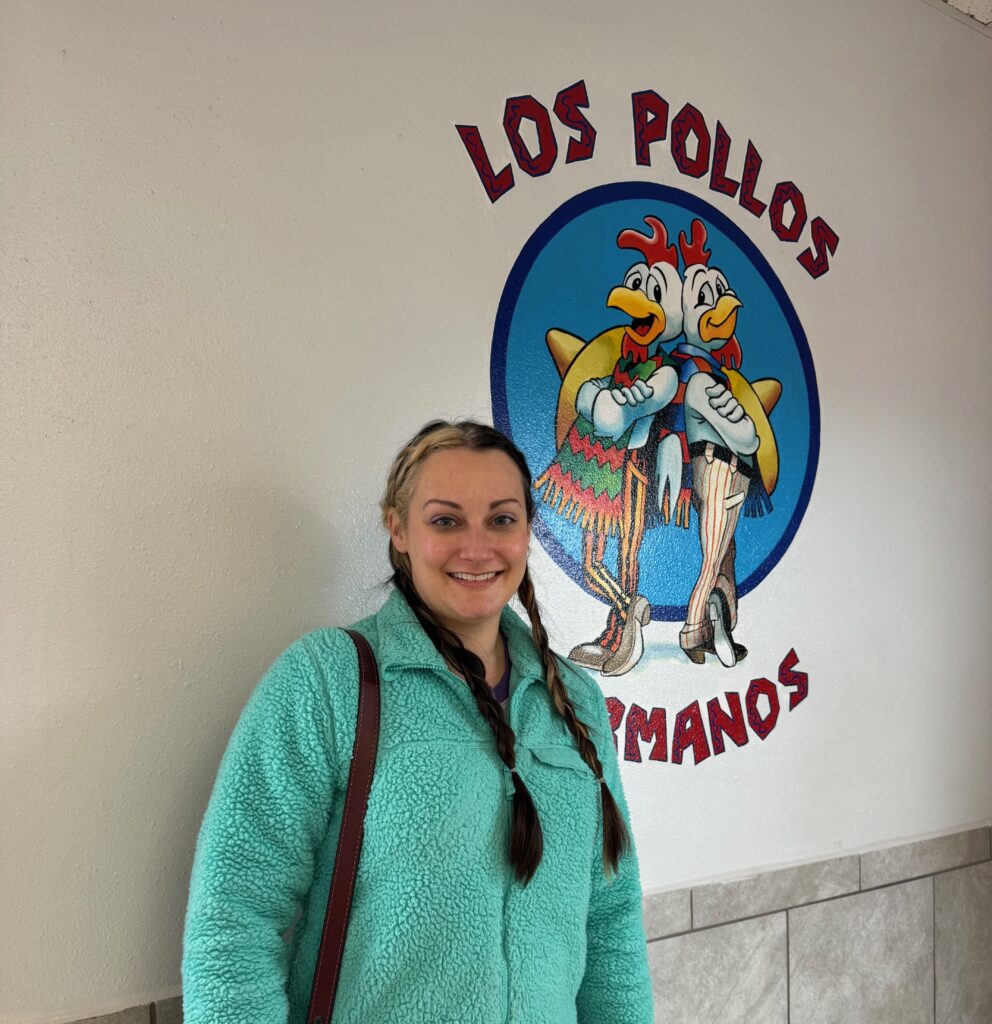 A woman standing in front of a sign.