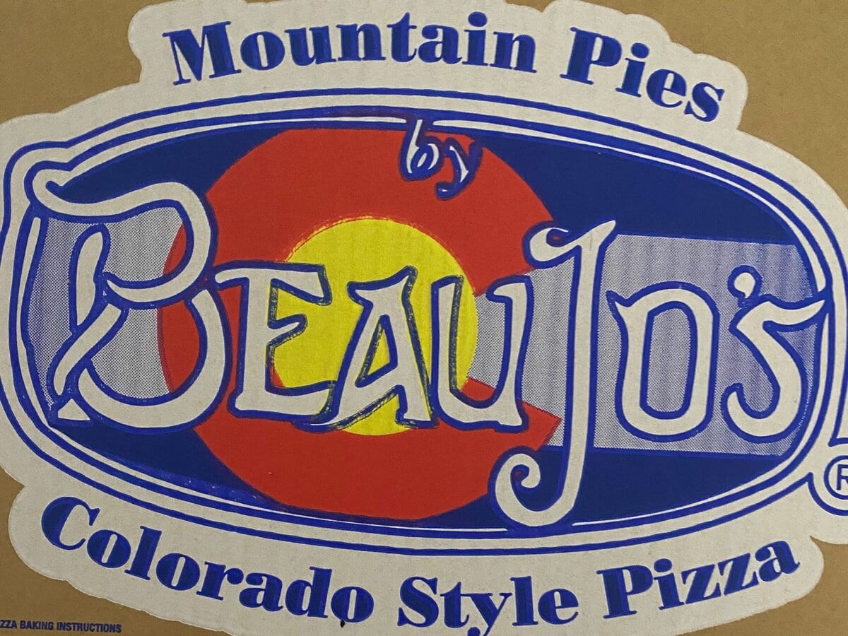 A cardboard pizza box featuring the Beau Jo’s logo, with Mountain Pies and Colorado Style Pizza written on it. Social media icons and the website BEAUJOS.COM are also displayed at the bottom.