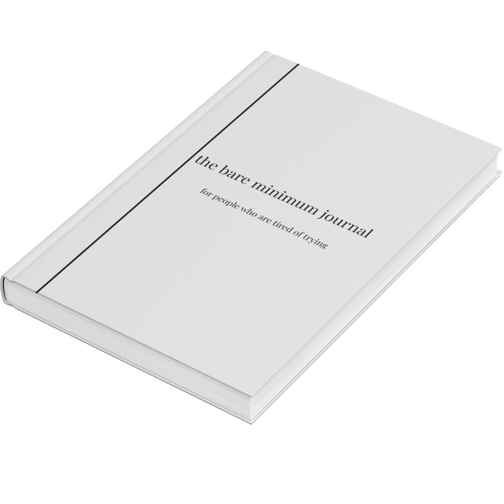 A white hardcover book titled the bare minimum journal with the subtitle for people who are tired of trying displayed on the cover.